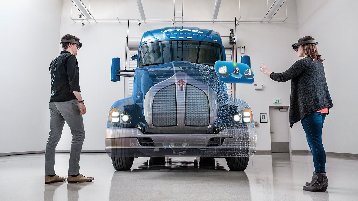 Man and woman wearing HoloLenses and working on a holographic body overlayed on a truck frame